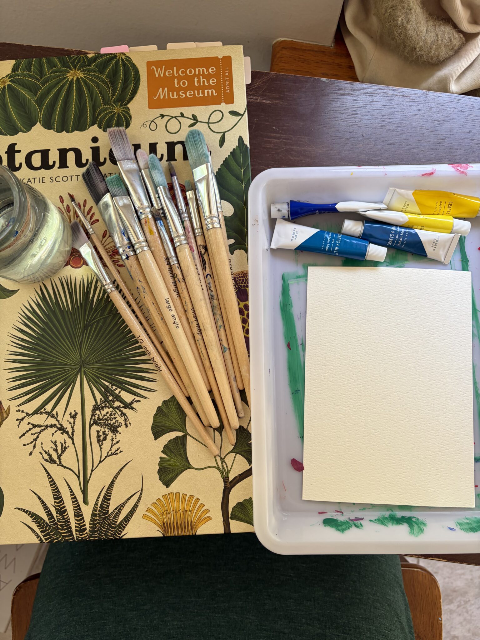 A pristine blank white canvas block resting flat on a studio table with early paint tests